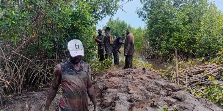 Kedzi and Aveta Residents Build Walkway on Flooded Road in Community Effort.